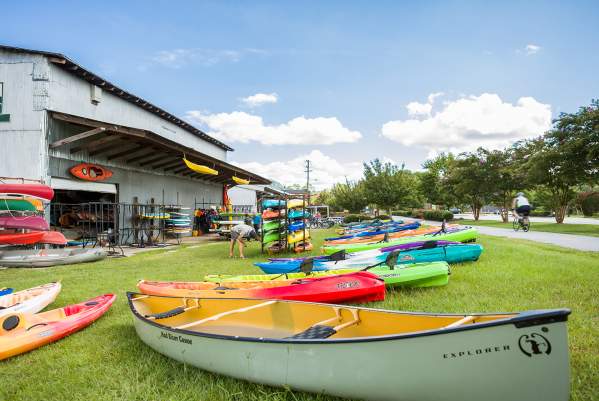 Several canoes sitting on the lawn of Sunrift Adventures Kayaks and Canoes.