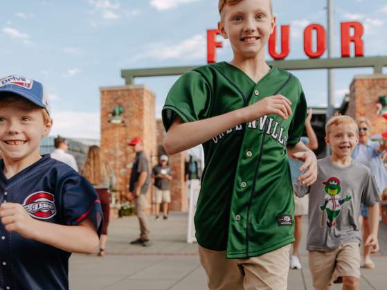 Boys running at Fluor Field baseball stadium, home of the Greenville Drive in Greenville, SC.
