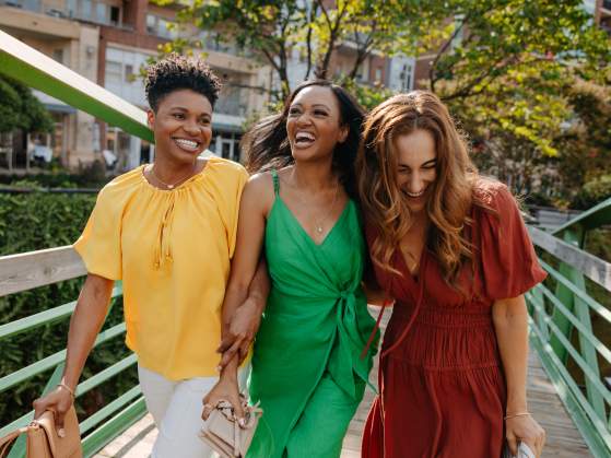 Three girls laughingly walk across the Eugenia Duke Bridge in downtown Greenville, SC.