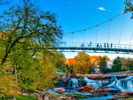 Pedestrians on the Liberty Bridge at the Falls Park on the Reedy.