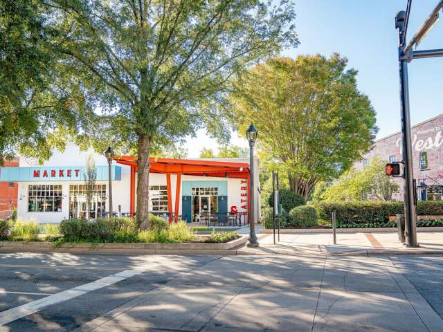 Exterior view of Spinx Market & Eatery on a sunny day with several trees nearby