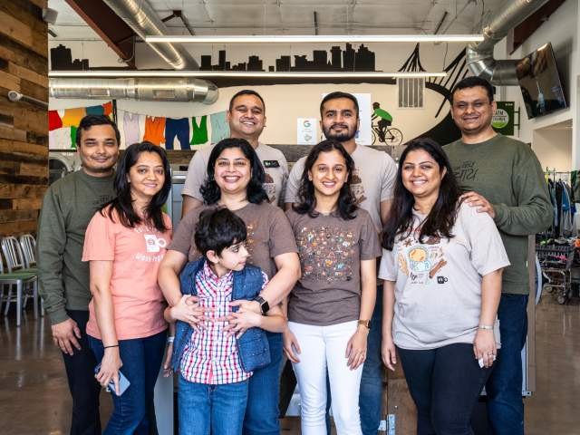Desai family posing in Green Laundry Lounge. Green Laundry Lounge vision is to reinvent laundromat & dry-cleaning system so community can take advantage to laundry services easily and spend quality family time in-store, from their lounge area and cafe, or at-home by having pickup/drop-off service.  Their goal is to use most energy efficient washers, dryers, sustainable and ecofriendly laundry products.