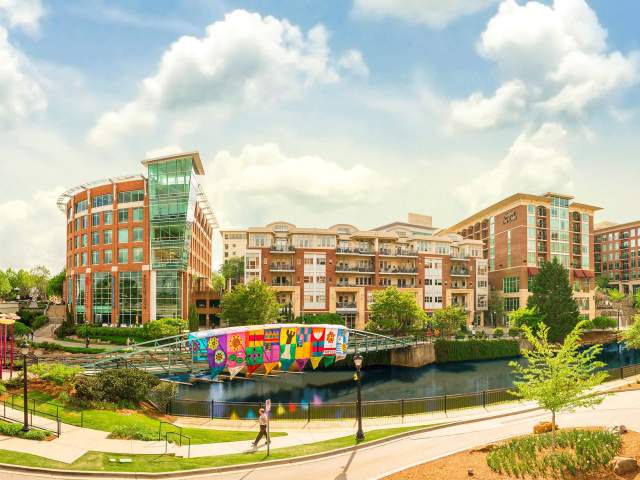 A colorful fabric banner covers the Eugenia Duke Bridge over the Reedy River.