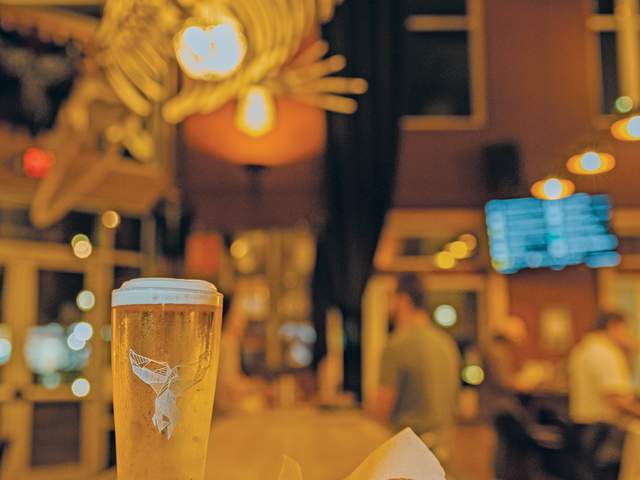 A craft beer sits on a wooden counter in The Whale GVL in downtown Greenville, SC.