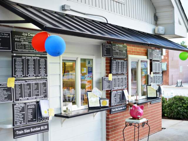 The exterior storefront of Ice Cream Station in Simpsonville, complete with colored balloons.