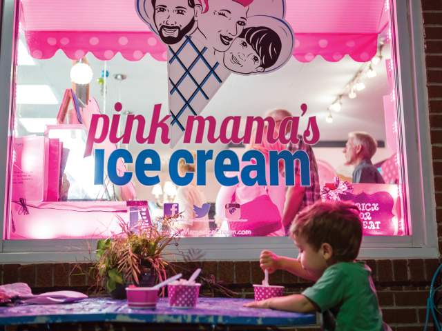 A little boy eats ice cream outside in the evening at Pink Mama's Ice Cream in Travelers Rest, SC.