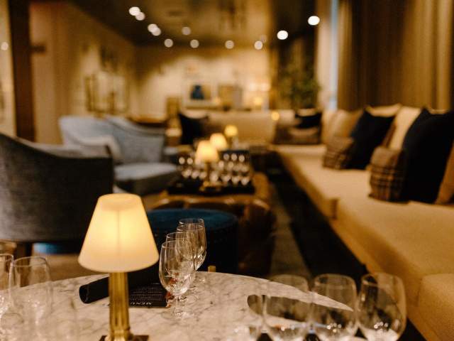 Couches and chairs line the walls in the dim, cozy atmosphere of The Press Room speakeasy in downtown Greenville, SC.