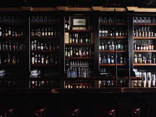 The bar area is filled floor-to-ceiling with different types of liquors at Swordfish Cocktail Club in downtown Greenville, SC.
