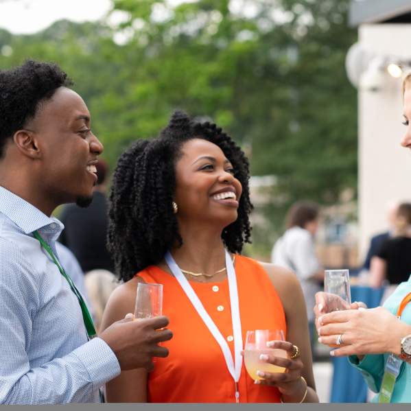 three people talking outside