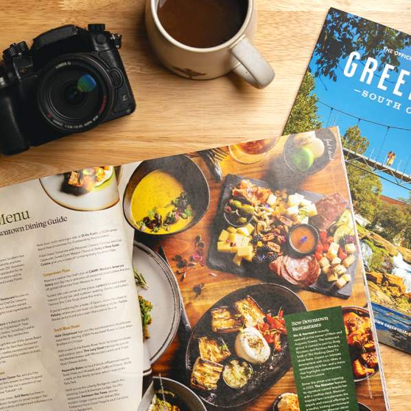 The 2025 Destination Guide splays open to an article on Downtown Dining in Greenville, SC.