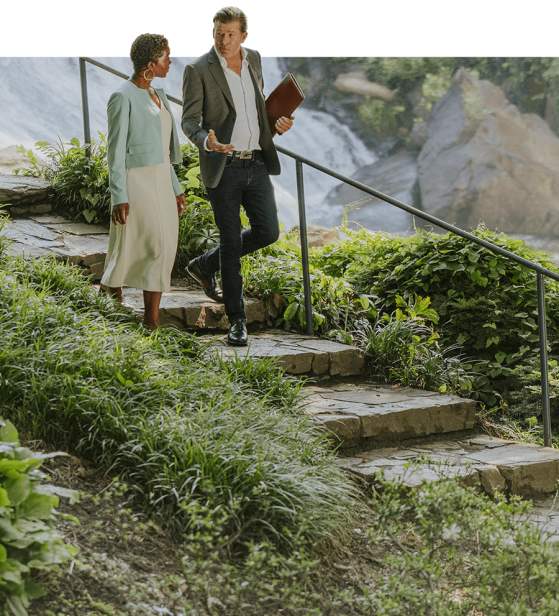 Two business professionals walking down stone stairs in Falls Park