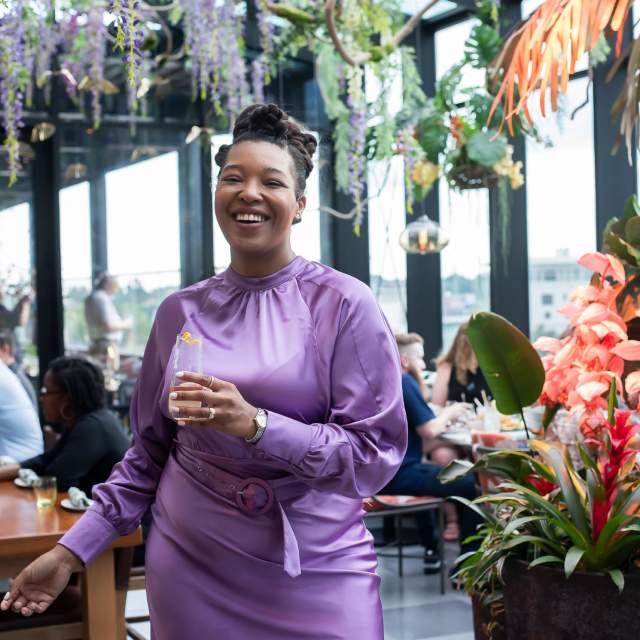 A classy woman in purple drinks a cocktail at Juniper in downtown Greenville, SC.
