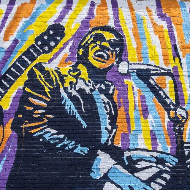 Ray Charles plays the piano in a mural on the side of The Practice Pad in Greenville, SC.