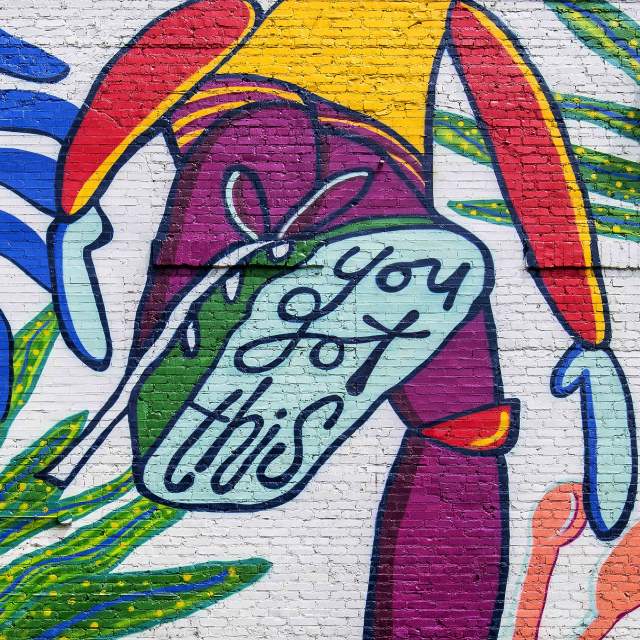 A mural on the side of Run-In in Greenville, SC with a person lifting their foot, which says "You Got This" on the bottom of the shoe.