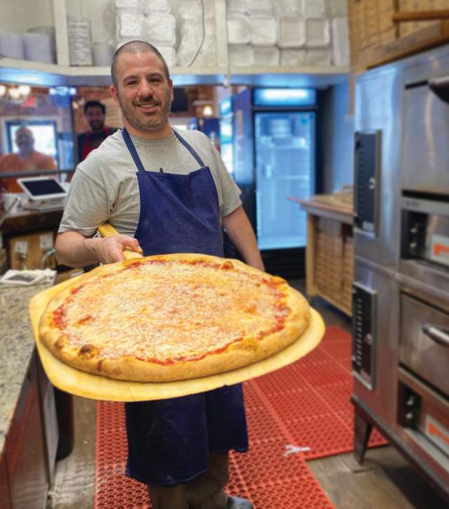 A man holding a cheese pizza
