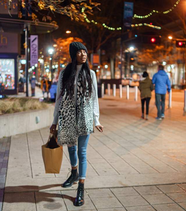 A woman shopping on main street decorated for Christmas