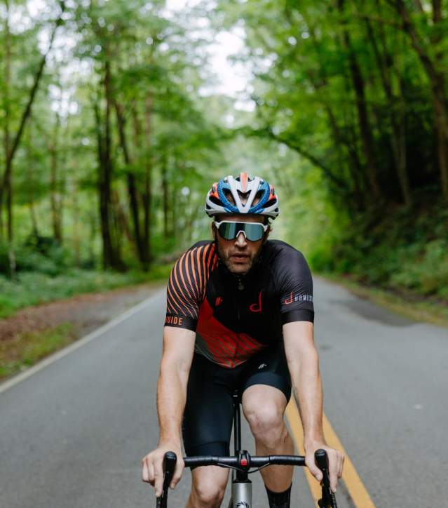 Man wearing a helmet on a bike, cycling in the road.