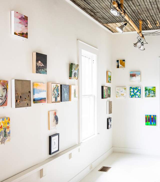A bright, airy gallery space with contemporary art displayed against white walls.