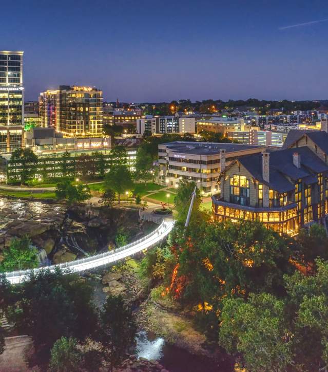 Downtown Greenville at night highlighting the LIberty Bridge, Falls Park on the Reedy and the Grand Bohemian hotel.