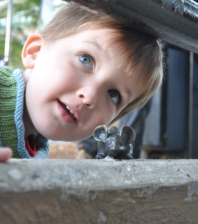 Kid discovering a mouse from the Mice on Main Scavenger Hunt
