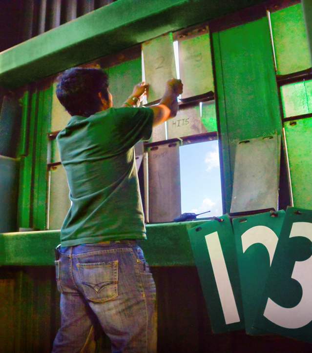 Worker changing the score on the board at Fluor Field.