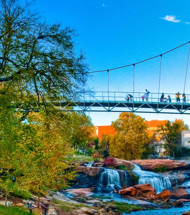 Pedestrians on the Liberty Bridge at the Falls Park on the Reedy.