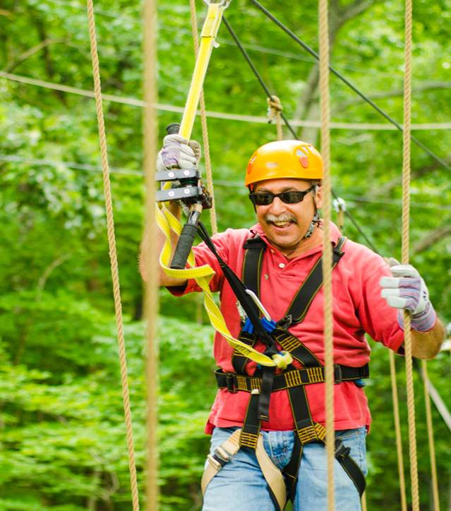 Man crossing a bridge at Green River Adventures in Saluda, NC.