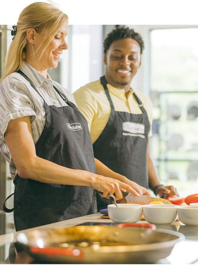 Two people showing off their culinary skills.