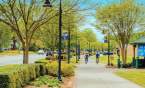 Two bikers cycling along the Prisma Health Swamp Rabbit Trail in downtown Travelers Rest, SC.