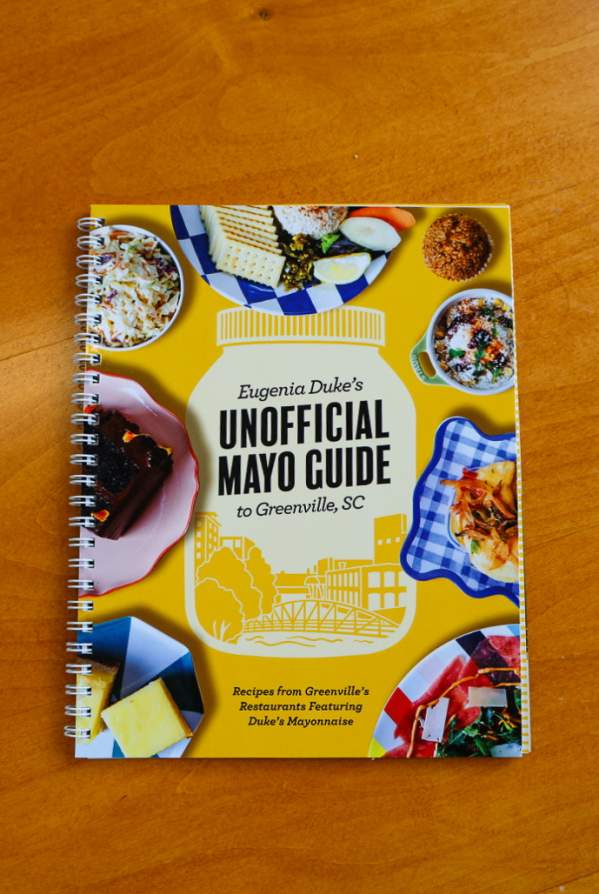 Eugenia Duke's Unofficial Mayo Guide to Greenville, SC Cookbook on a wood tabletop