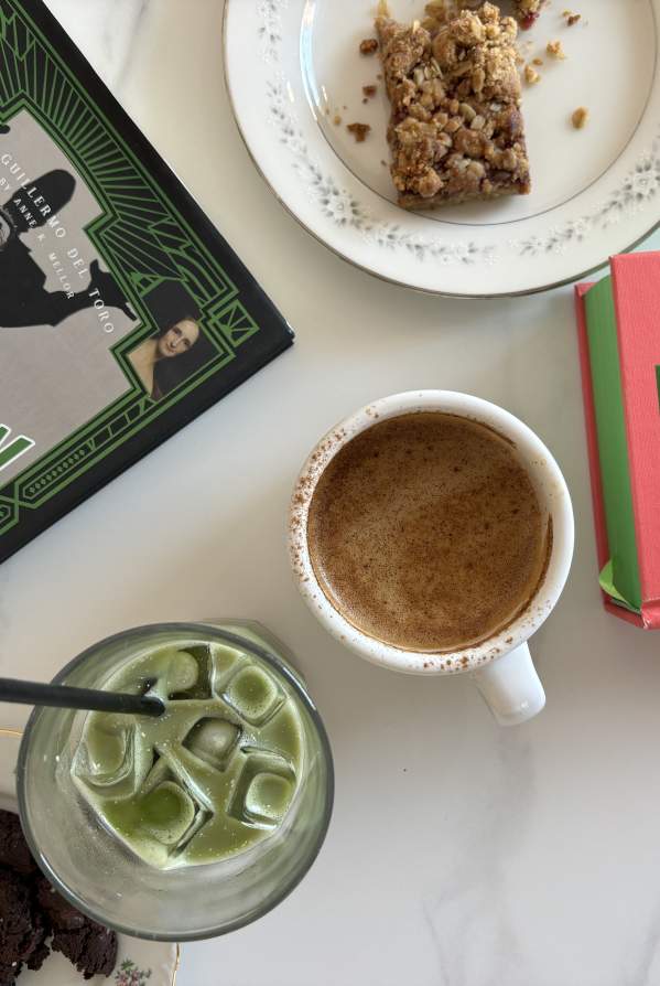 A table with pastries and coffee & matcha from Camilla Kitchen and books from M. Judson Booksellers.