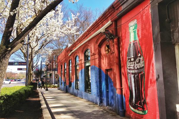 Mural of a Coca-Cola bottle on a building.