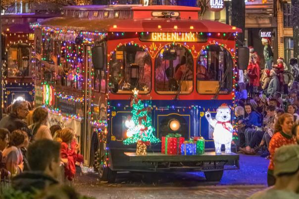 A Christmas-decorated free trolley makes its way down Main Street during the annual Poinsettia Parade held every December in Greenville, SC.