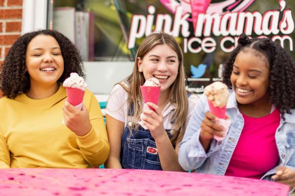 Three kids happily eat their pink ice cream cones at Pink Mama's Ice Cream in Travelers Rest, SC.