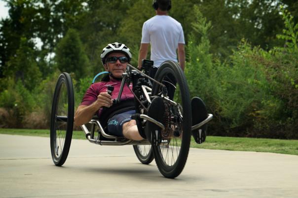 Man using a hand cycle on the Swamp Rabbit Trail in Greenville, SC.