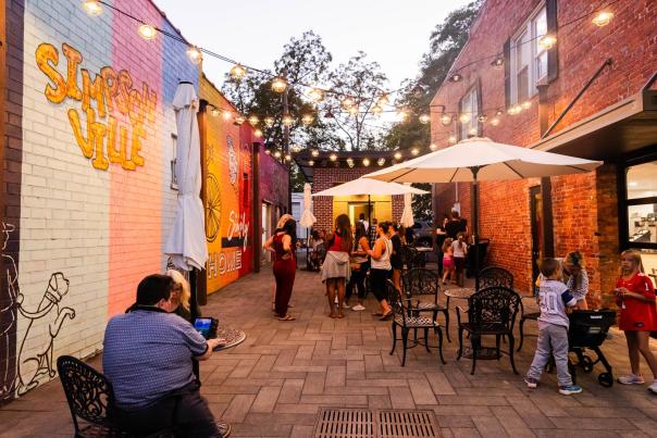 Crowds enjoy outdoor dining near murals in downtown Simpsonville, SC.