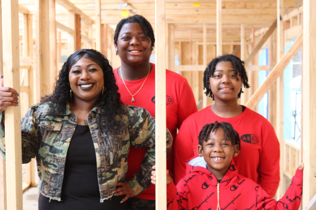 A family standing in their home under construction.