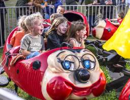 Children laughing and riding a themed attraction at Conner Prairie’s Headless Horseman event.