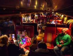 Families seated inside a festively decorated Reindeer Ride train car from Nickel Plate Express during the holidays.