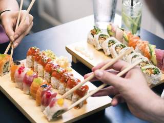 Two bamboo dishes with colorful sushi rolls