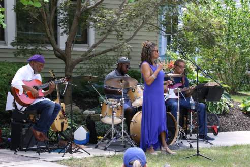 Musicians performing outdoors on a porch for the Noblesville Porch Fest.