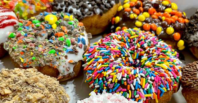 A close-up photo of various colorful, sprinkle-covered donuts at Ohana Donuts & Ice Cream.