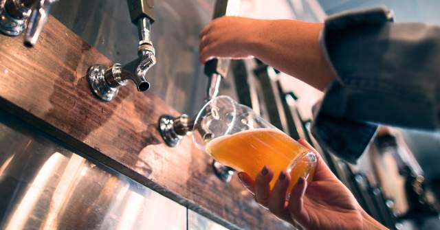 Hand pouring beer from tap