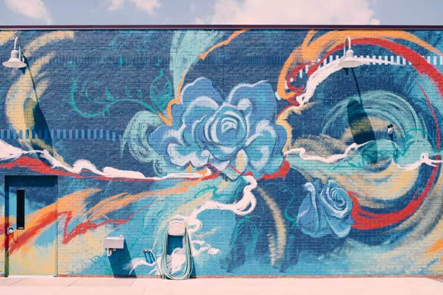 A close-up of a colorful mural featuring large blue flowers and red abstract shapes.