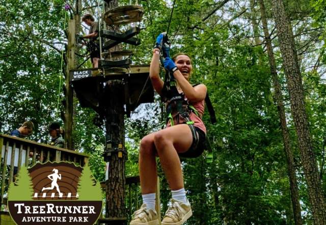 girl on zip line at the TreeRunner Adventure Park in Grand Park