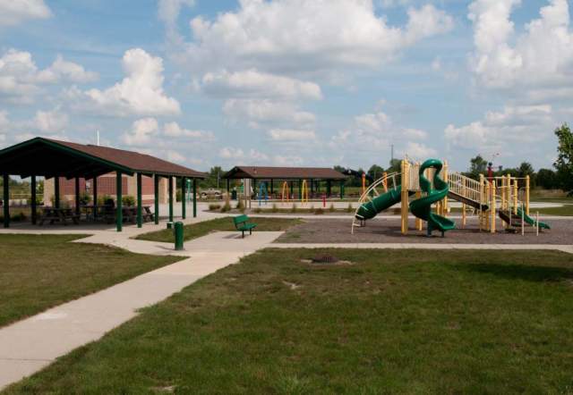 Outdoor play structure with slides next to a covered picnic area.