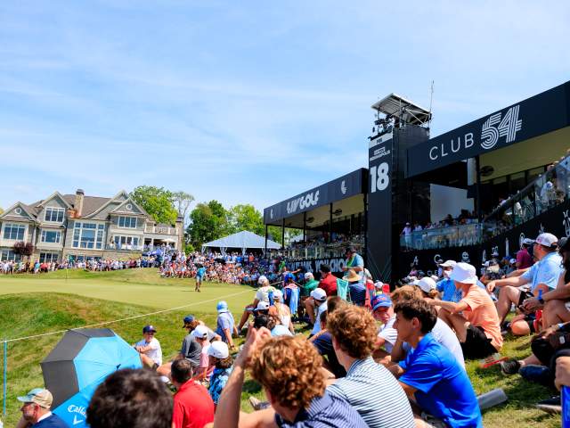 Outdoor community festival, with crowds gathered around a golf course in Indiana.