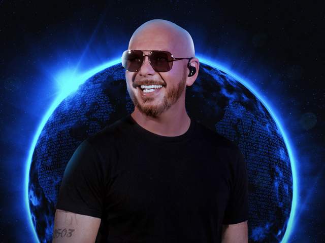 A bald man wearing a black T‑shirt and an in‑ear monitor stands against a glowing blue planet set in outer space, creating a dramatic, futuristic concert-style visual.