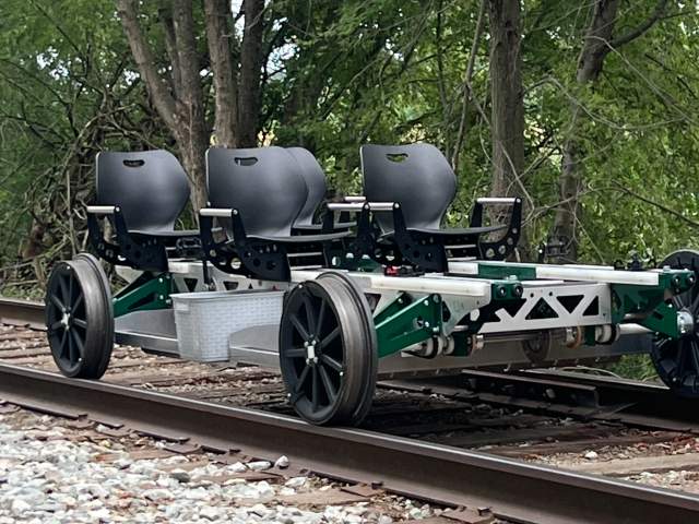 Railbike carts lined up on train tracks ready for a recreational rail-riding experience.