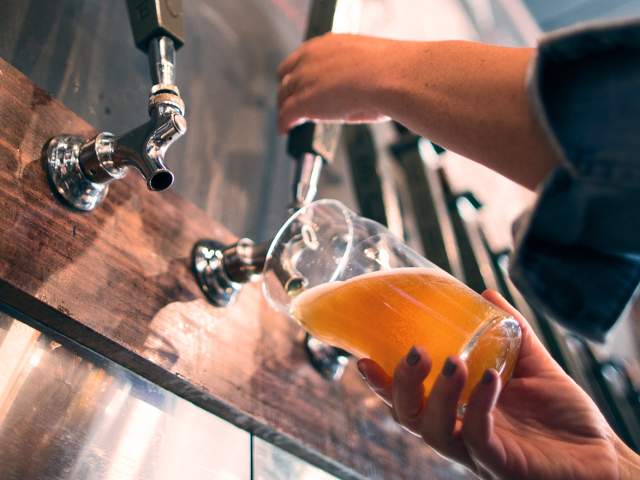 Hand pouring beer from tap